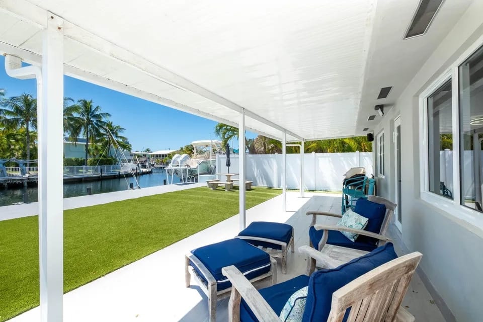 Waterfront patio with lounge chairs and canal views