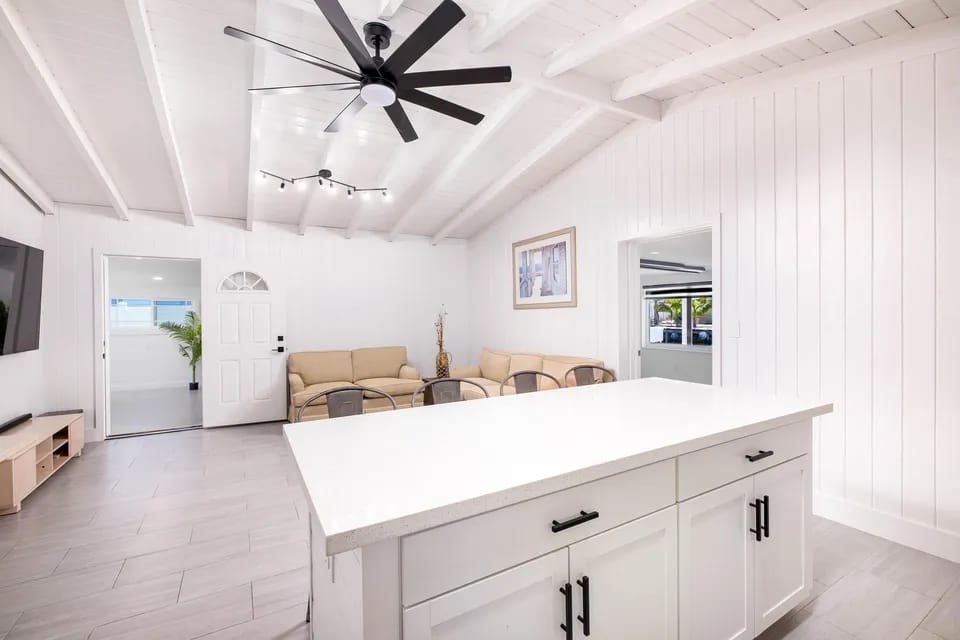 Open-concept kitchen and living room with white cabinetry